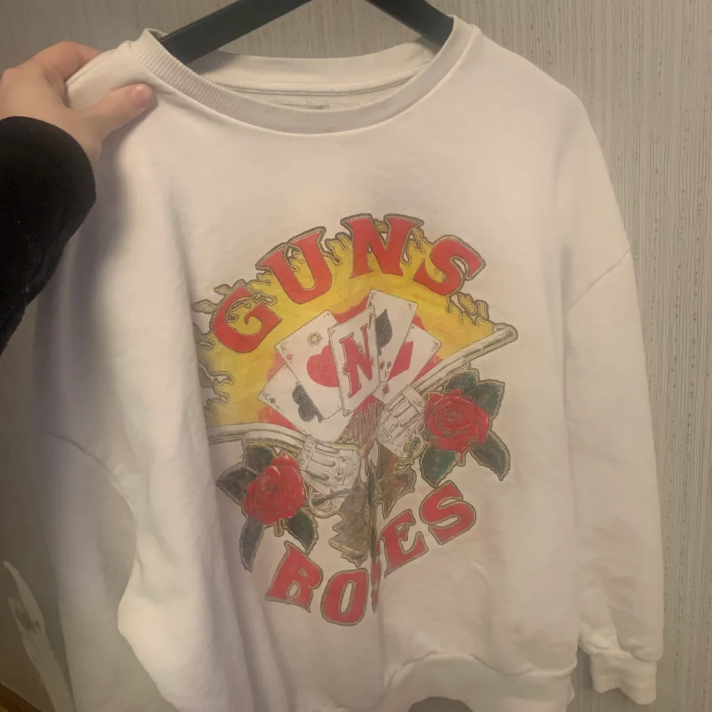 Vit Guns of roses tröja, bra skick men har en mini fläck på höger sida som säkerligen går bort i tvätten. Därav priset. Köptes på pull and bear för ett tag sedan för över 400kr. Tröjor & Koftor.