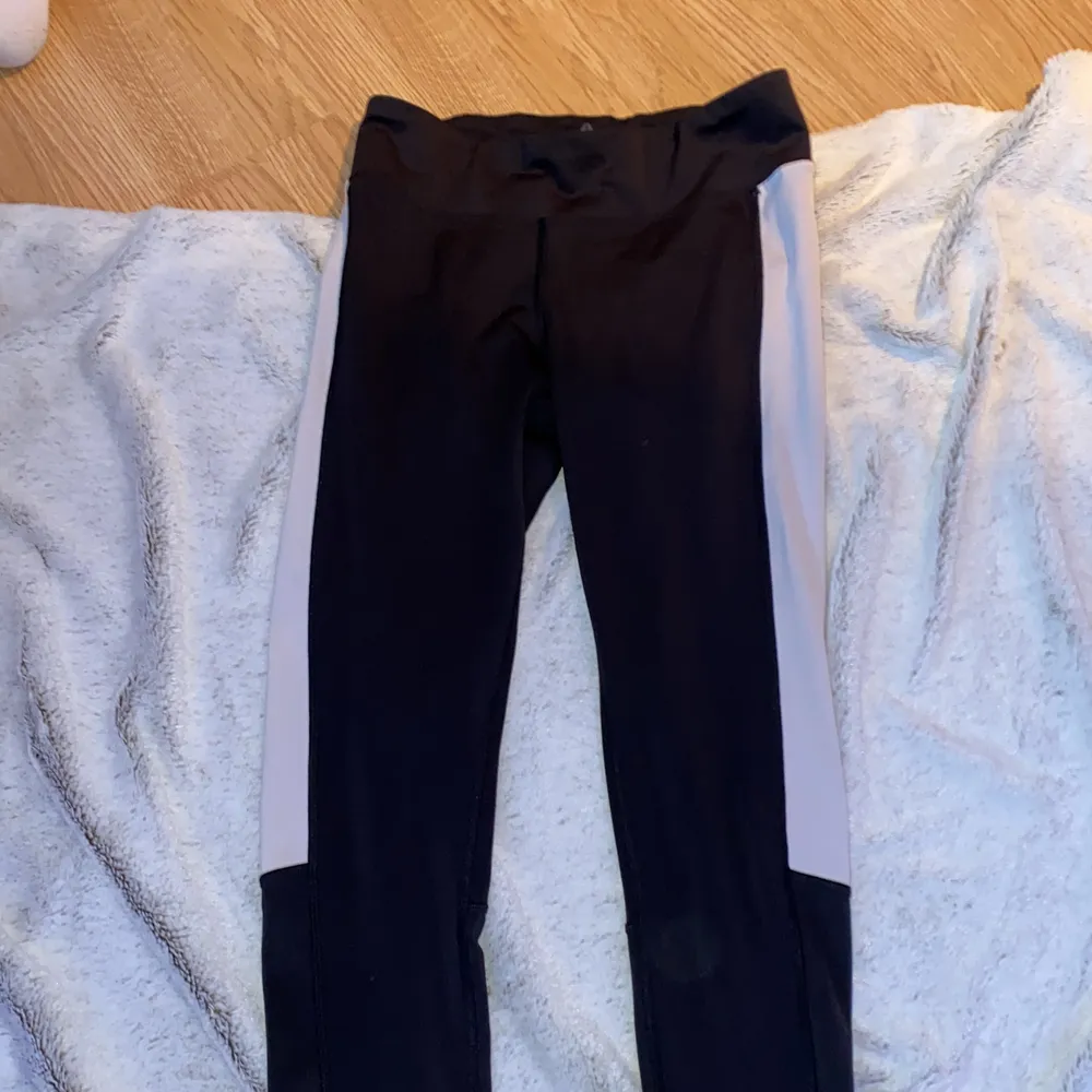 Svarta träningsbyxor men vita detaljer, halvt lågmidjade, bra passform . Jeans & Byxor.