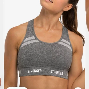 Stronger - Grå stronger sporttopp, strl M. Medium support. Jättehärligt och stretchigt material. Vaddering går att lägga in. Köpt för 399kr, säljer för 150kr +frakt! Betalning sker via swish.🥰