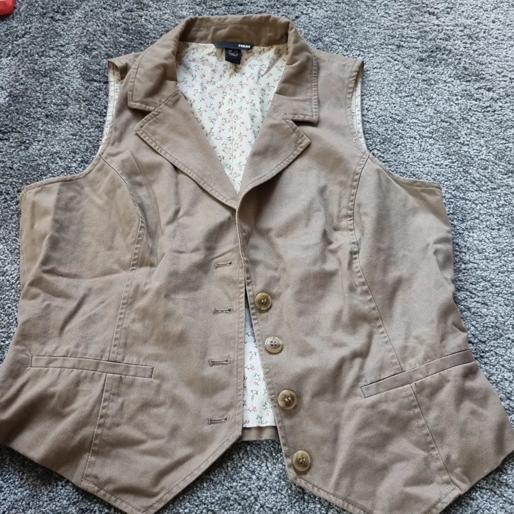 En beige/brun väst från H&M i storleken 44 . Övrigt.