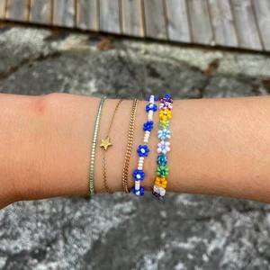 Pärlarmband med blommor - Jag säljer 2 handgjorda pärlarband med blommor. Varje armband kostar 72kr och då är frakt inkluderat i priset. Går att köpa separat eller tillsammans!!