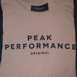 En smuts rosa Peak pearformance långarmad tröja strl L - Tröjan är ett gammalt plagg som inte använts på länge men fortfarande i bra skick. Den är i storlek L men är liten i storleken. Formen är liten i midjan men stor vid höfter och axlar. Vill även tilllägga att köparen står för frakt