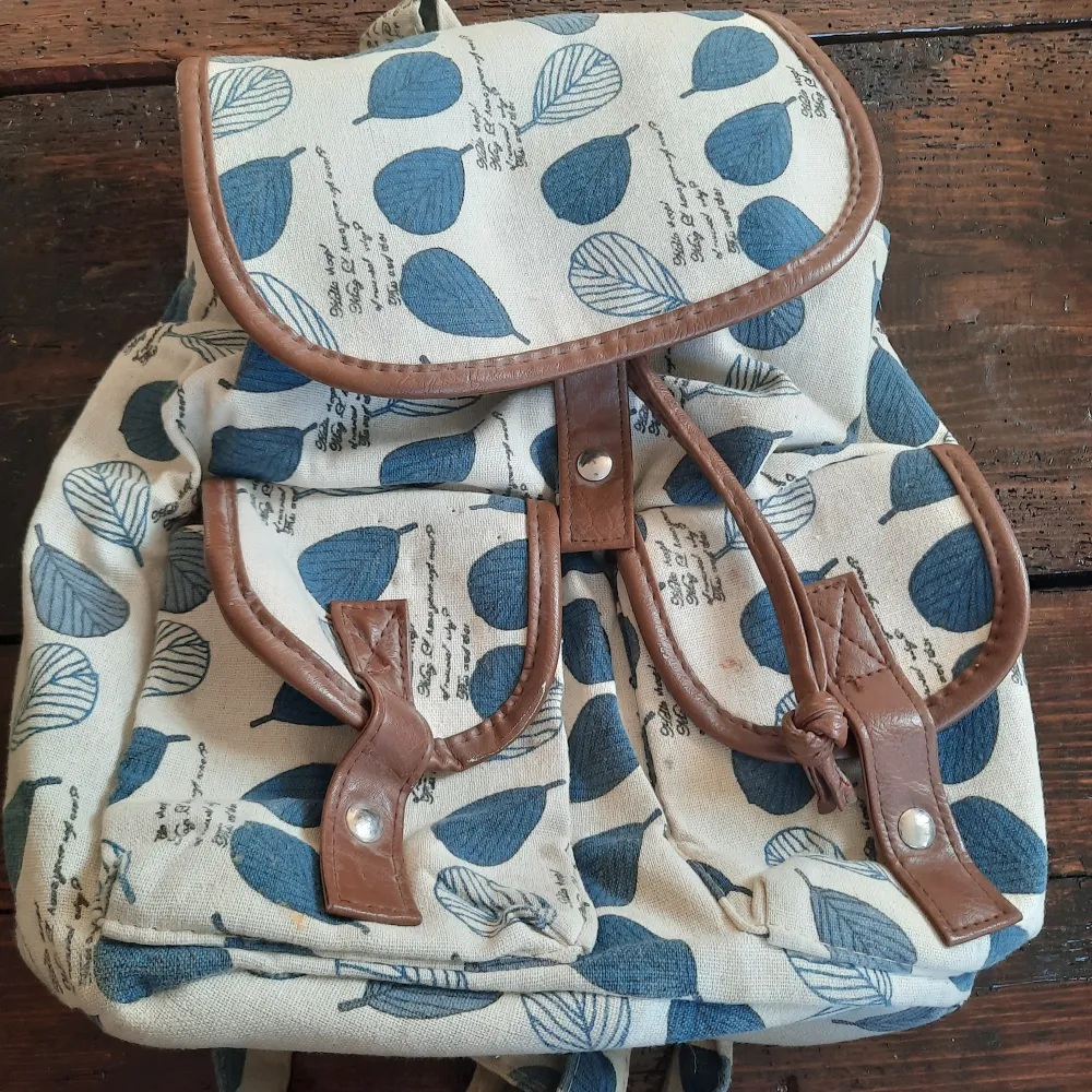 Snygg tyg ryggsäck med läder och blåa blad detaljer. . Väskor.