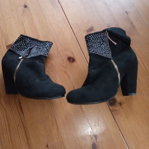 Stövlett med glitter stl 41 (38-39 ). - Helt nya och oanvända svarta stövletter med glitter stl 41 .mer som stl 38 /39. Med klack ca 10 cm höga .hämtas i Skene alt skickas o köpare betalar frakten o Swishbetalning tillämpas .frakt inräknat i priset .(104 ).