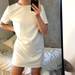 Vit klänning Nelly - Supersöt rak klänning med knytning bak från Nelly som tyvärr inte kommer till användning! Kan tänka mig att den blir väldigt fin med något som markerar midjan om man vill ha den mer figursydd! Passar mig som är 169 och vanligtvis har S/M!🤍  