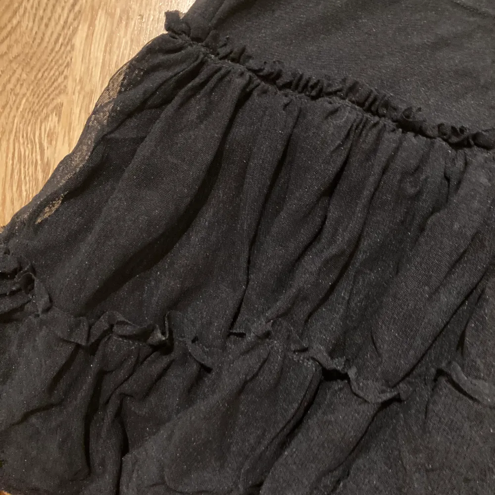 En svart kjol som är lågmidjade och puffig.. Kjolar.