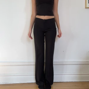 Kostymbyxor - Svarta lite utsvängda kostymbyxor. Har en turkos rand längst upp som man ser på 2:a bilden. Men jag brukar bara vika ner den. OBS damm på sista bilden ej smuts.