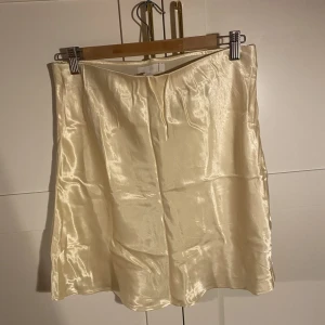 Silkeskjol - Ljusgul Silkeskjol från H&M med resår i midjan. Aldrig använd, nypris 199kr. Frakt tillkommer