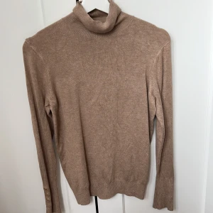Beige polo från zara  - Beige polo från zara med guldiga knappar på ärmarna.
