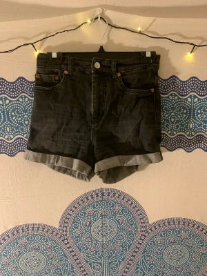 Shorts - Mörk grå/ svarta shorts med hög midja i stretch denim. 28 i storlek. Dom har rullat upp sig lite där bak vilket är lätt fixat, men annars i jättebra skick.