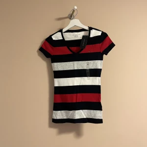 Tommy Hilfiger - En Tommy Hilfiger T-shirt i storlek XS, helt ny med prislappen på! Nypris 320 kr, säljer för 200 kr! 