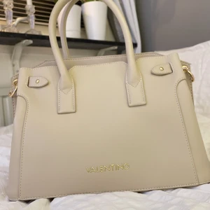 valentino väska  - Äkta valentino väska, använd 1 gång och köpt för 3-4 månader sen. inga märken och ser helt ny ut. kommer med ett axel band också. pris kan diskuteras beroende på. 