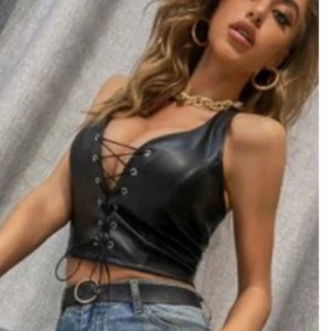 Skinn topp - Skit snygg skinntopp, som är med knyte i nacken. Helt ny