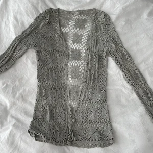 Virkad tröja - Fin virkad tröja med knappar. Den är grå/silvrig. Väldigt fint skick. Passar storlek xs-m skulle jag säga. 