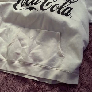 Coca cola hoodie - Vit coca cola hoodie, den är i storlek L men jag har storlek S och den såg ut som en vanlig oversized hoodie på mig! :) Säljer pga att det riktigt inte är min stil