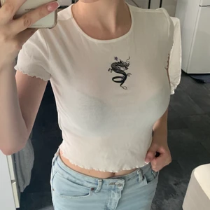 Vit topp med tryck - En vit topp som jag köpte för längesen på h&m i storlek XS. Aldrig använd💞 köparen står för frakt :)