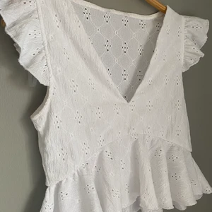 Vit Topp - Söt topp/blus med lite mönster, kontakta ifall det finns frågor. Finns fler bilder med hur den sitter på!