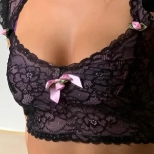 Milkmaid spets topp - Första bilden är lånad!  Köpte den här toppen men satt inte riktigt som jag tänkte mig. sjukt fin topp i svartspets med rosa mesh under! Små rosetter som gör toppen sjukt fin! Den är storlek XS men tkr den passar nån som har större byst i så fall🤍