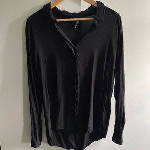 Svart skjorta - Svart skjorta i bra men använt skick. Strl XL enligt lappen men jag skulle säga att den är strl M i verkligheten. 