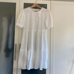 Ny vit klänning, exv fin studentklänning! - Köpte denna extremt fina klänning som ett alternativ för studentklänning, men den var tyvärr för kort för mig så den är helt oanvänd och jag säljer nu vidare. Passar suveränt både som student, midsommar eller sommarklänning. Nypris: 599kr lapp sitter kvar