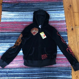 Ed hardy hoodie - Fortf kvar!! Köpt second hand så har lite cracks i trycken. Tag finns kvar står det är xl men passar S. Materialet är som juicy couture dressarna