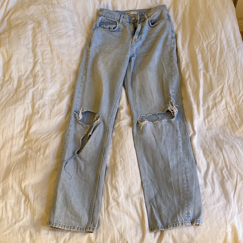Högmidjade jeans från Gina Tricot med hål på knäna. Ena hålet är lite mer upprivet. I storlek 34.. Jeans & Byxor.