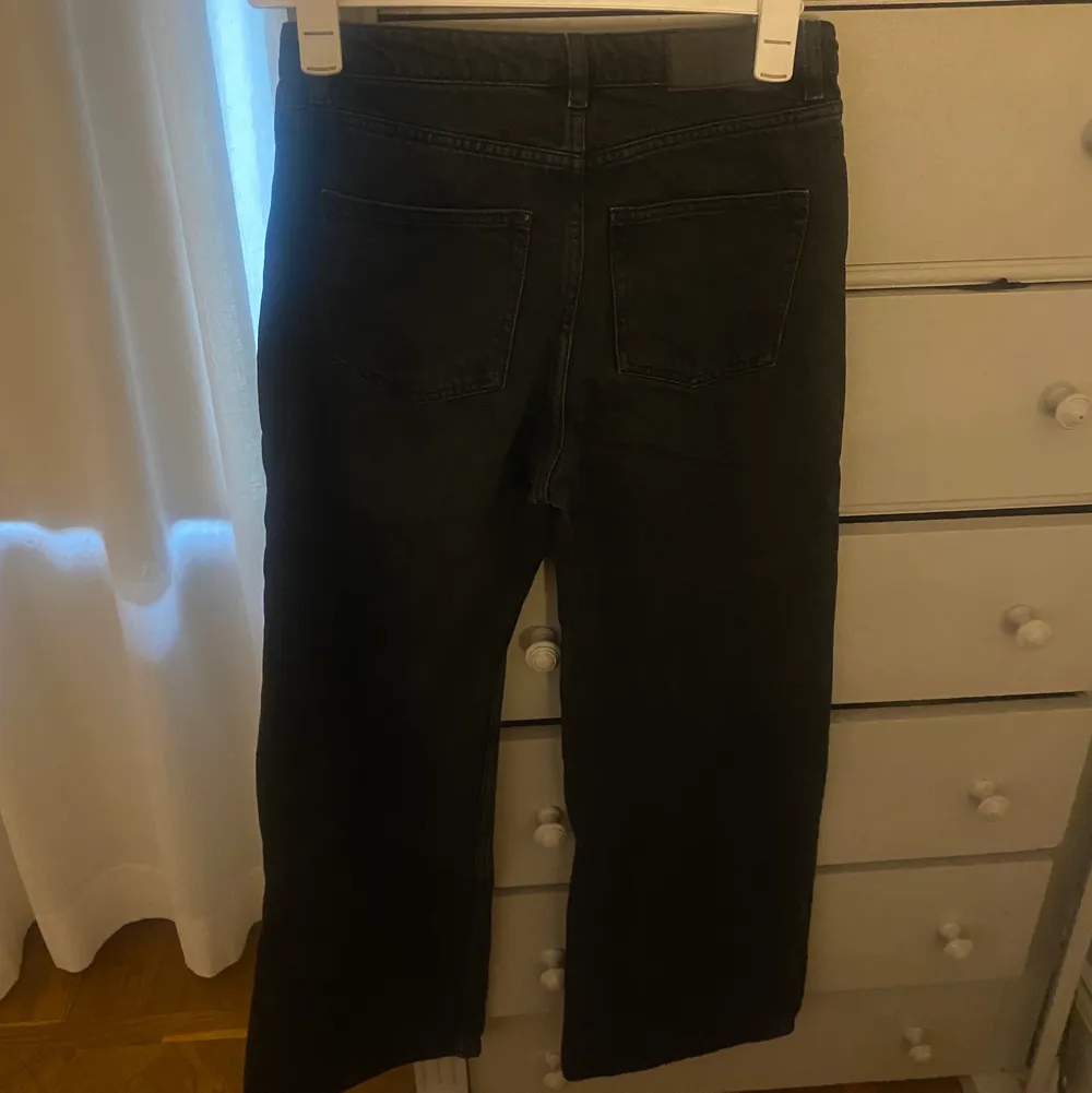 Ett par svarta utsvängda monki jeans. Jeans & Byxor.