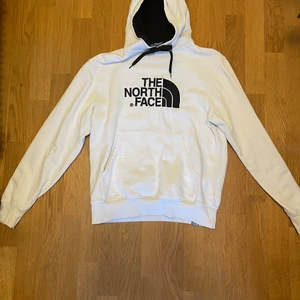 The North face hoodie vit  - Riktigt schysst vit the north face hoodie, Säljer den då den tyvär har blivit lite liten. Har tyvär blivit lite hål i framsidan av tröjan men är annars i bra skick. Pågrund av att den har lite små hål och är lite gammal så
