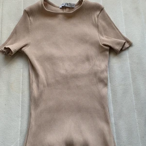 Topp  - Skit snygg topp från Na-Kd. Toppen är i en ljus beige färg med en fin öppning vid ryggen. Perfekt till sommaren och passar snyggt till det mesta. Den är i storlek S. Priset kan diskuteras😁.