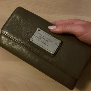 Marc Jacobs plånbok - Plånbok från Marc by Marc Jacobs. Grå/beiget läder. Nypris ca 2000kr. Inköpt på tidigare MArc Jacobs-butiken på Norrmalmstorg, Sthlm.