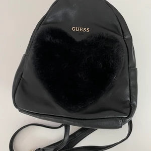 Guess mini heart backpack - black mini backpack from Guess with a faux fur heart patch at the front. fully lined. adjustable shoulder straps. 