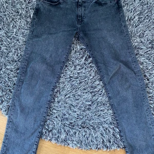 Levis 502 gråa jeans - Säljer ett par Levis jeans model 502 storlek 30/32. De är ett par jeans med en fin grå färg och med svarta segment. Säljer dem då de är för stora för mig, de är inte använda särskilt mycket och de är i väldigt bra skick. Ordinarie pris är 1099kr.