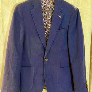 Säljer min sons blå linnekostym i stl 48. Kavaj och byxor med blommigt foder i slim fit modell. Nyskick. Endast använd en gång när han gick ut 9:an 