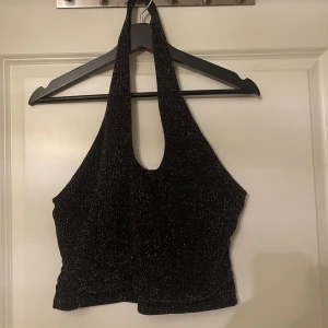 Glittrig festtopp - Supersnygg svart/silver glittrig fest topp. Sparsamt använd och i mycket fint skick.