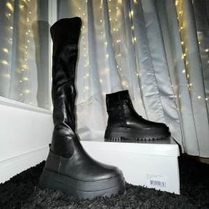Overknee boots från Nelly - Svarta över knä boots i skinnimmitation. Testats en gång. Väldigt ”formfitting” och snygga! Kommer i lådan dom kom i från början. Original pris: 999kr