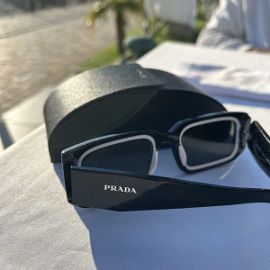 Prada solglasögon - Prada solglasögon  Modell PS 06YS Inköpta för 6 månader sen, säljs pga använder inte tillräckligt mycket.   Skicket är väldigt bra, en lite mindre repa på en osynlig vinkel på glasögonens övre kant (ej glaset).   Nypris ca 3000kr  