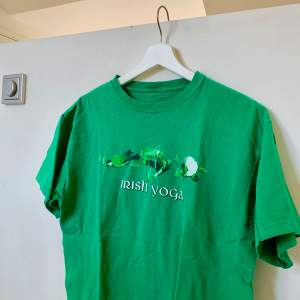 En grön tshirt med motiv, ”irish yoga” i storlek M