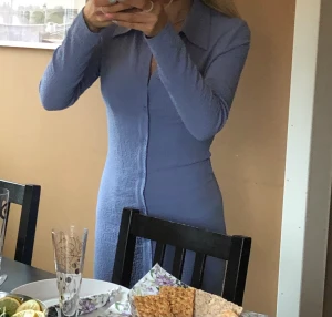 Skjortklänning - Från monki, bra skick. Svår att fånga färgen på bild men lite mörkare än ljusblå och mer klar i färgen än vad som syns på bild. På mig som är 1,60 är den till mitten av vaderna 