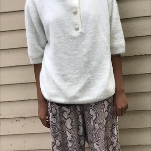 Vit och lurvig vinter tröja. - En oanvänd riktig skön lurvig tröja som är perfekt till vintern och hösten. med jätte snygga pärlor, diamanter som gör hela tröjan så mycket snyggare den ser fancy ut och man kan styla den jätte snyggt.