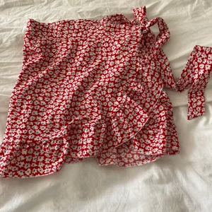 Volang kjol - Jättesöt röd blommig kjol somt tyvärr inte kommer till användning. Skriv vid frågor!!