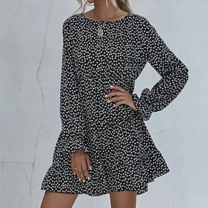 Klänning - Svart jättehärlig kort klänning. Den är lika som på ”modellbilderna” men v-ringad i halsen. Ny, ej använd. Svart m små vita blommor. Resor i midjan. Samfraktar gärna med mina andra annonser