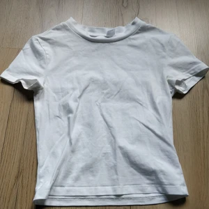 Vit t-shirt - Vit, croppad typ "babytee" från H&m. Knappt använd så i fint skick! Passar bra på mig som brukar ha S, har även en likadan i svart på min sida! Skriv om du har några fågor eller om du vill ha fler bilder! 😊🤍