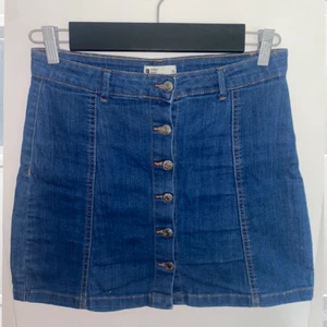 Gina tricot, srl 138 - Jeans kjol med knappar framtill från Gina tricot. Superfin passform dock lite liten för mig. Fint skick! Köparen står för frakt