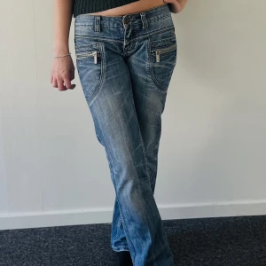 lågmidjade jeans - Sjukt coola lågmidjade jeans med dragkedja detaljer.  Midjemått: 80cm 