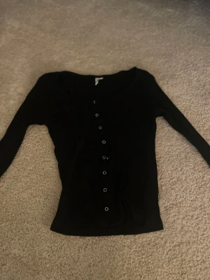 Svart tröja med knappqr - Svart tröja med knappar från Nelly 
