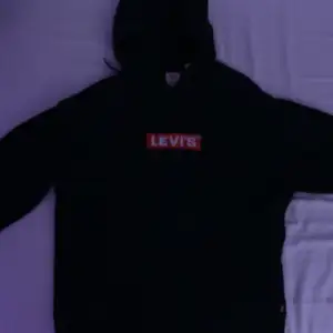Det är en svart Levis hoodie med röd box logo. Ifall ni vill ha fler bilder så kontakta mig!  Skick 8,5/10 typ ny. 