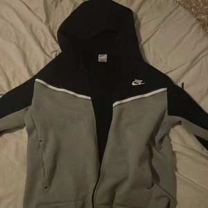 Nike tech grå svart/ stl:M - Anväd sen ungefär 2 månader tillbaka.  Ny pris/ 1200kr. Bra kvalite. Skick 8/10 bara ett litet hål på vänster armen som inte syns.