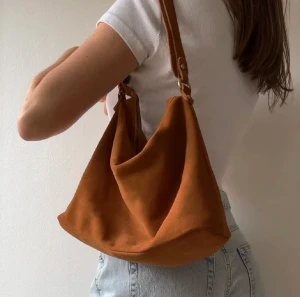 Axelväska  - Orange axelväska från Åhléns. Köpt här på plick, lånade bilder från förra ägaren. Använd fåtal gånger så är i bra skick! Säljer då den tyvärr inte kommer till användning.