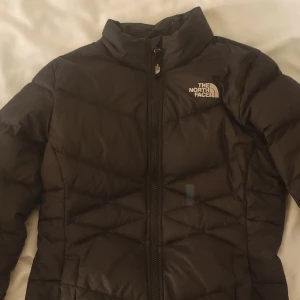 North face jacka - Svart( färgen ser lite konstig ut på bilderna men är svart) nortfacejacka i strl M barn, skulle säga att den sitter som en 150🤍en blå lagningslapp på framsidan men går enkelt att byta till en svart🤍