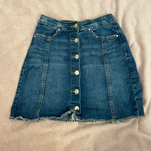 Blå jeans kjol - Blå jeans kjol med knappar. Använd ett par gånger och är i bra skick. Sitter tajt.
